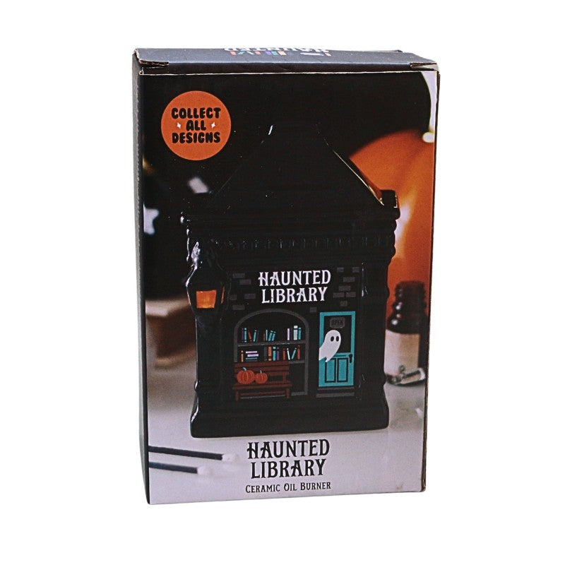 packaging box featuring ceramic oil burner in the shape of a building with ghost and book images on, titled "haunted library"