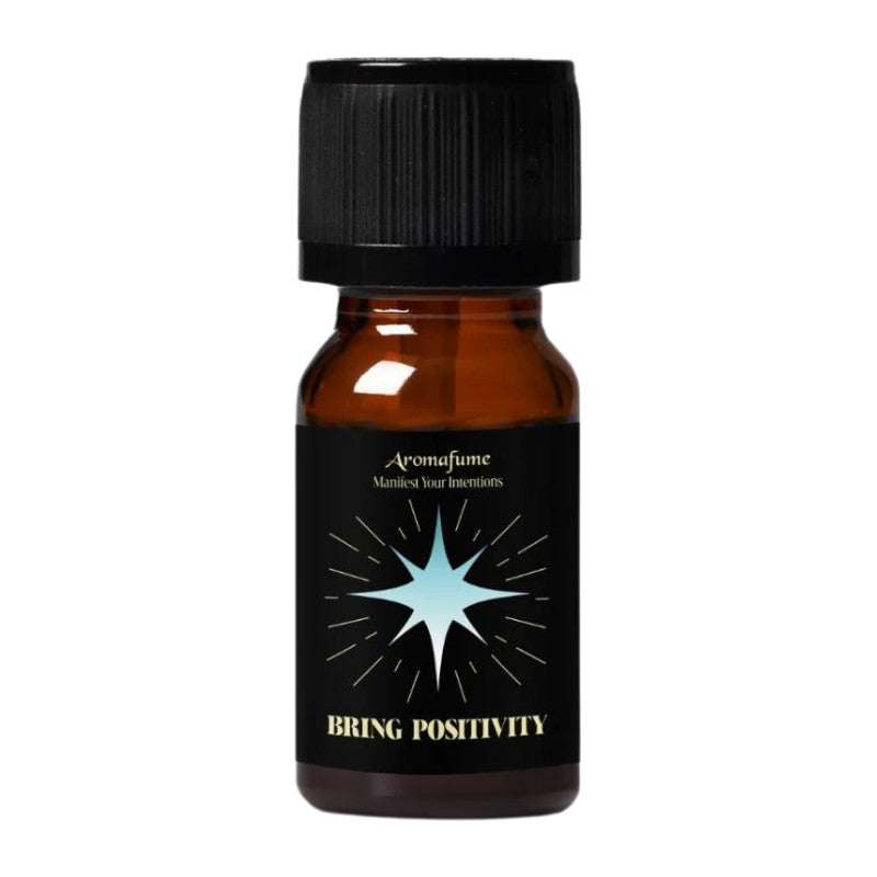 A small amber glass bottle with a black ribbed cap and a black label featuring a light blue starburst and the text 'Aromafume' and 'BRING POSITIVITY'.