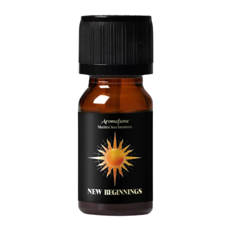 A small amber glass bottle with a black ribbed cap and a black label featuring a yellow and orange sun graphic and the text 'Aromafume' and 'NEW BEGINNINGS'.