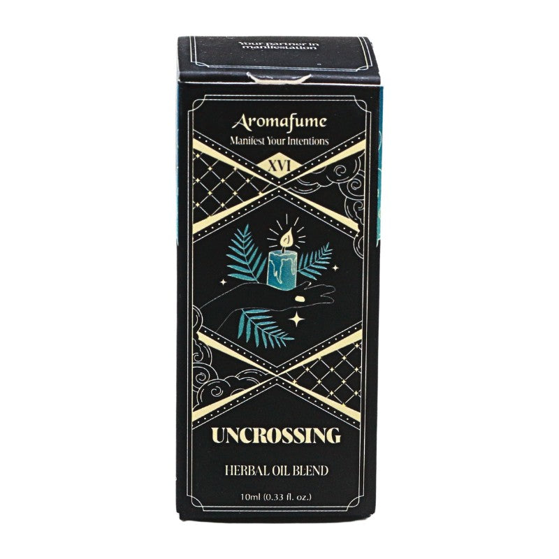 A rectangular black box for Aromafume 'Uncrossing' Herbal Oil Blend, featuring gold geometric borders and teal illustrations of a candle and leaves on a white background.