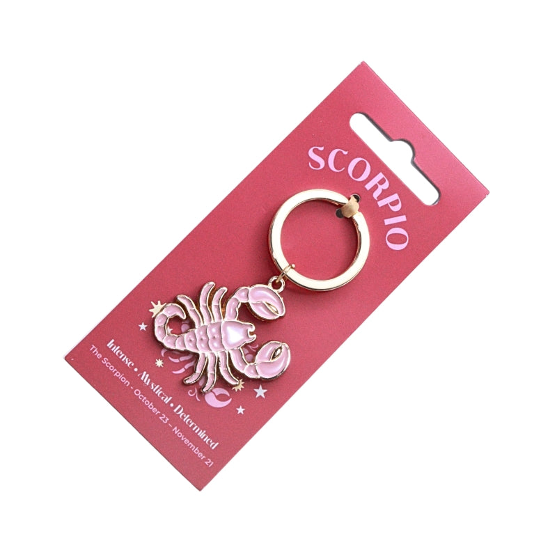 A pink and gold Scorpio zodiac charm key ring attached to a pink retail display card, photographed on a plain white background.