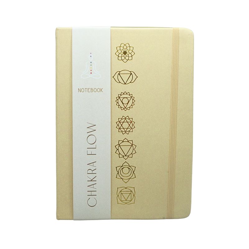 linen cover diary with the chakra symbols printed in gold on the cover. Gold edged pages and a tag with the words "Chakra Flow" and "Notebook" covering it.