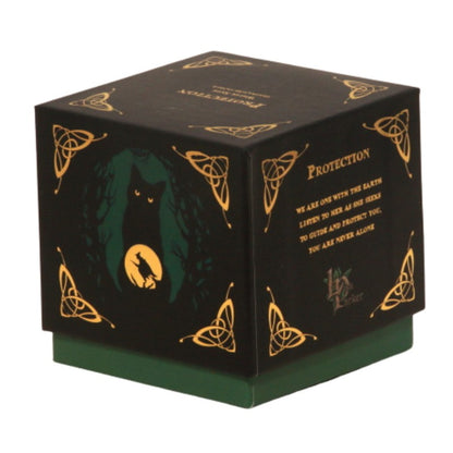 candle gift box-black with green and gold- featuring a black cat and witch flying on a broomstick- on front with the word "protection" written in gold on top.