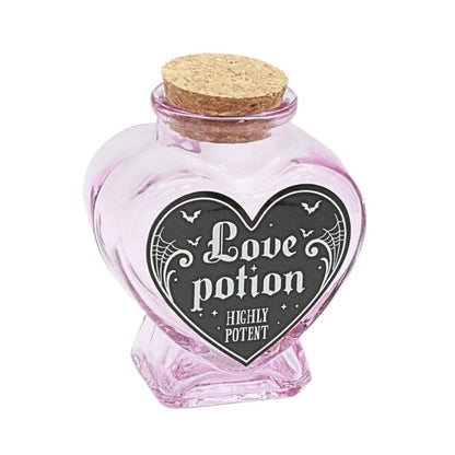 Heart-shaped pink glass jar with cork lid labeled 'Love potion Highly Potent' on a white background