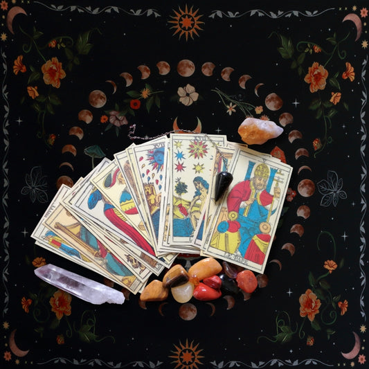 Tarot cards and crystals laid out on a floral  tarot cloth 
