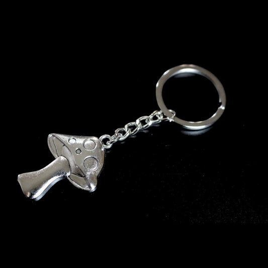 silver coloured key ring with a mushroom  joined to a silver ring by a silver chain on a black background