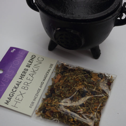 magickal herb blend- hex breaking for incense and magickal use. Sitting in front of a black cauldron