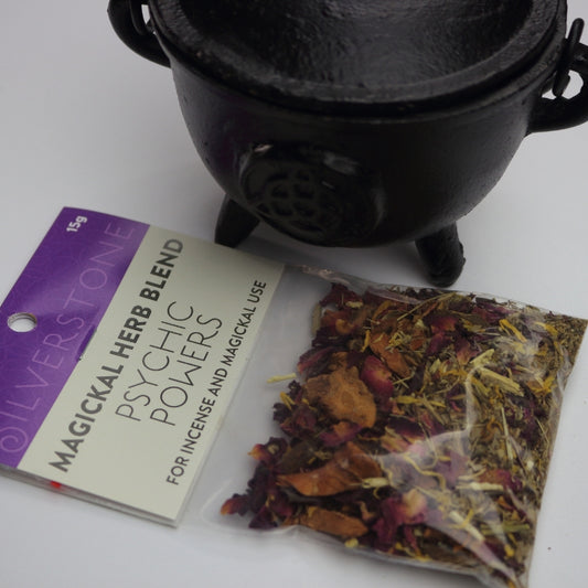 packet of magickal herbs for increasing  psychic powers, in front of a black cauldron