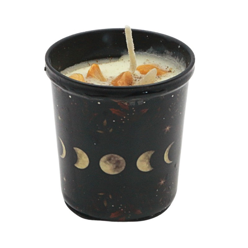 Black candle container with moon phase design containing a lit candle on a white background