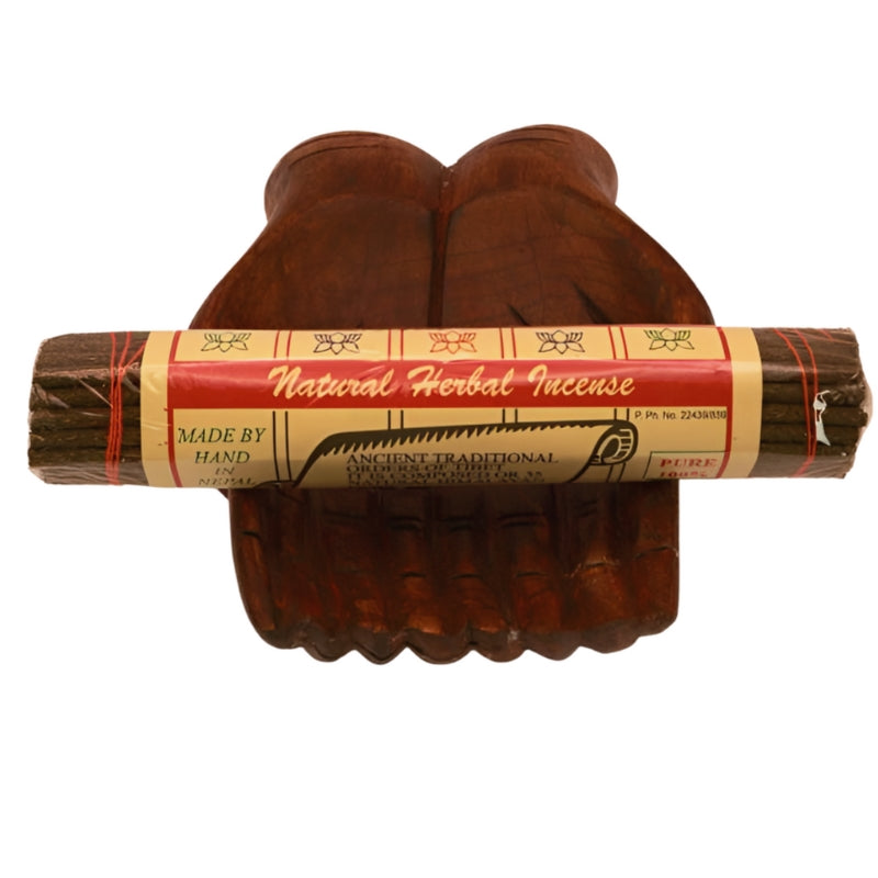 pk of hand rolled "Natural Herbal Incense" tibetan incense sitting on a statue of carved wooden hands