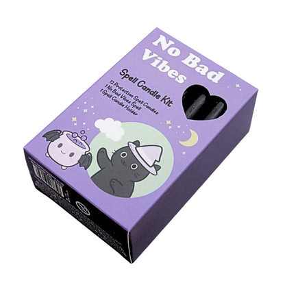 A purple cardboard box for a 'No Bad Spell Vibes' spell candle kit, featuring cute illustrations of a black cat in a wizard hat and a white bunny, with a heart-shaped window showing black candles inside.