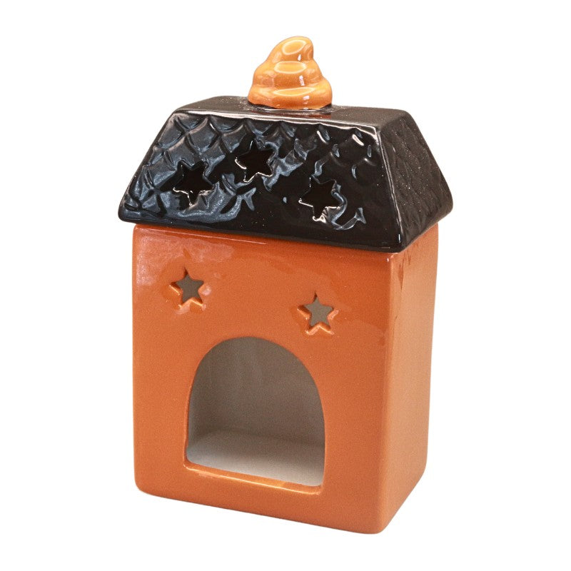 A small ceramic decorative house-shaped vessel with an orange body, a black roof, star-shaped cutouts on the front, and a small orange topper on top, shown on a plain white background.