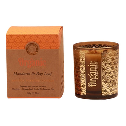 organic goodness candle box next to soy candle in a brown and gold votive candle jar