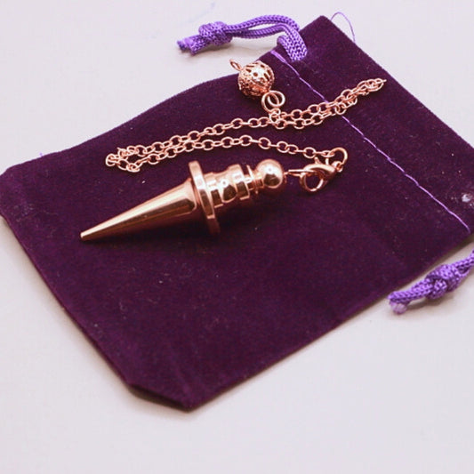rose gold pendulum on purple velvet bag