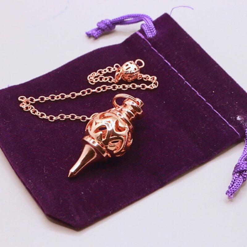 rose gold pendulum on purple velvet bag
