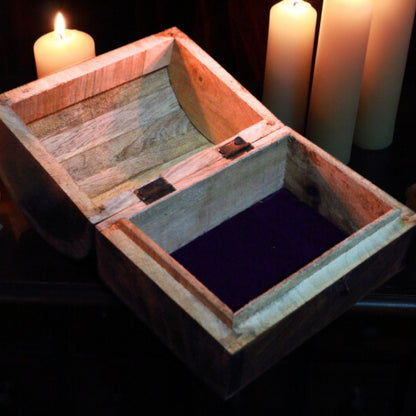 showing the inside of wooden chest with beeswax candles in background