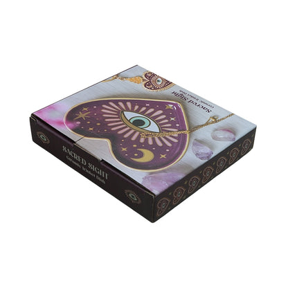 cardboard packaging box showing a purple/pink heart shaped ceramic trinket dish with an eye in the centre, on a white background