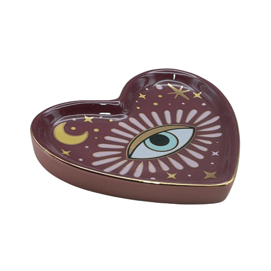 purple/pink heart shaped ceramic trinket dish with an eye in the centre, on a white background