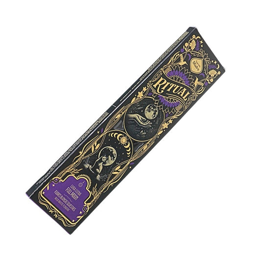 A rectangular box of Ritual brand incense sticks, featuring a black background with ornate gold illustrations and purple accents, including a snake and moon design.