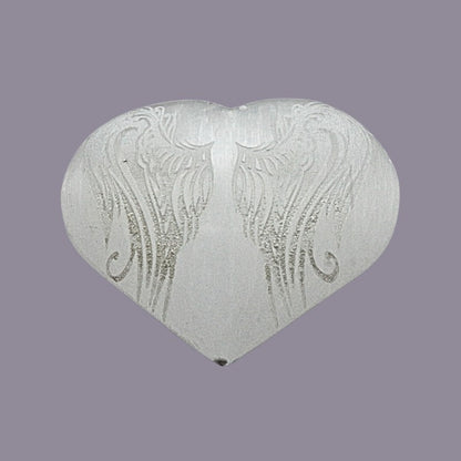 Heart-shaped object with angel wings patterns on a purple background