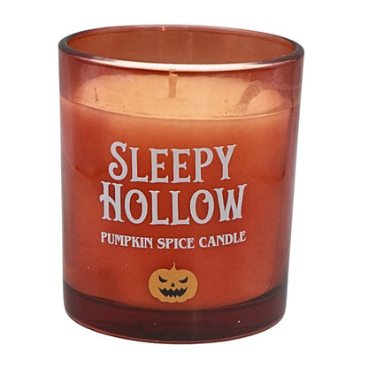 Orange canlde with white writing and a pumpkin design 