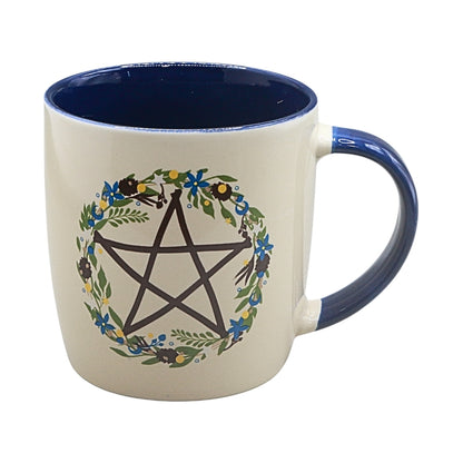 cream coloured mug with blue handle and a pentagram design in a floral wreath 