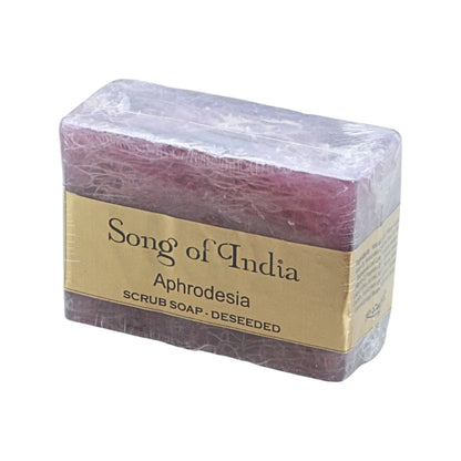 A rectangular bar of deseeded Aphrodesia scrub soap by Song of India, wrapped in clear plastic with a gold paper label, on a white background.