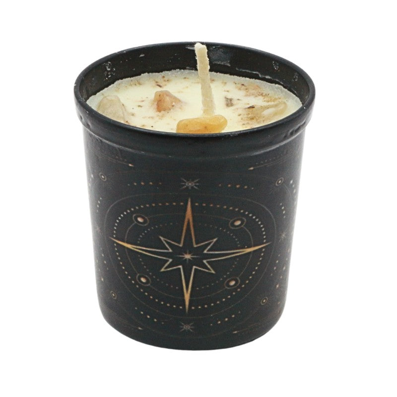 Black candle holder with star design containing a lit candle on a white background