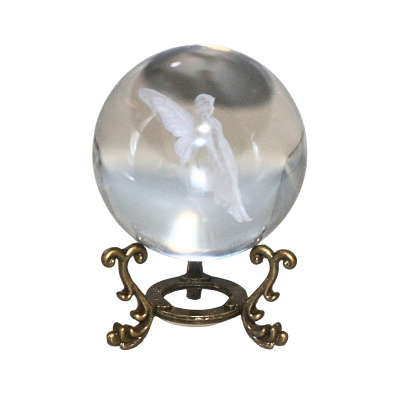 A clear glass crystal ball with a white angel figure inside, displayed on an ornate bronze-colored stand against a plain white background.