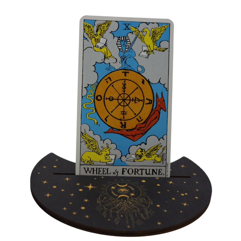 tarot card "wheel of fortune" sitting in a tarot card holder (flat piece of wood designed to hold a card upright)