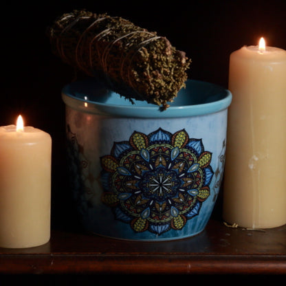 mandala smudge bowl next to beeswax candles with a juniper smudge stick 