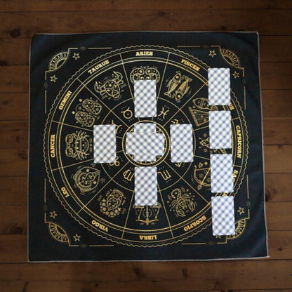 celtic cross spread laid out on a black tarot cloth /altar cloth with astrological symbols printed in yellow