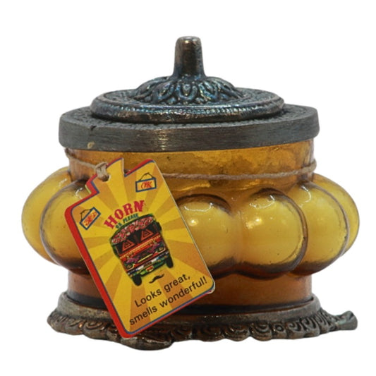 yellow ornate glass candle jar with a metal lid