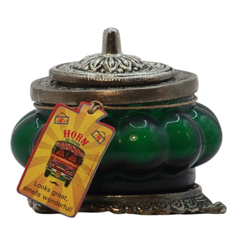 green ornate glass candle jar with a metal lid