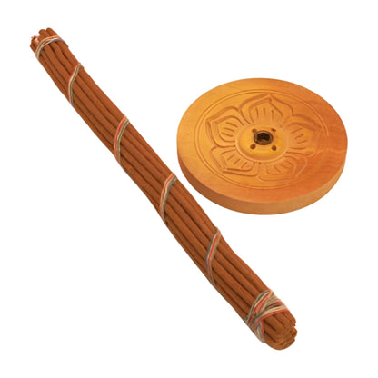 Round wooden carved incense holder- light wood  next to a bundle of tibetan incense sticks