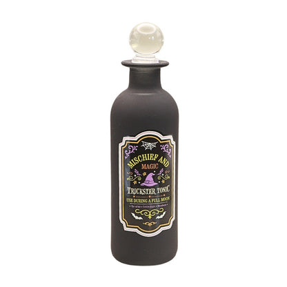 decorative black bottle with round glass stopper and a green and purple spooky design label with witches hat design