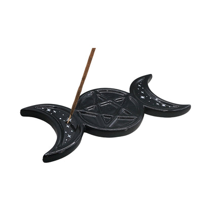 A black ceramic triple moon and pentagram incense holder with a brown incense stick, shown on a plain white background.