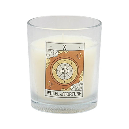 Candle in a glass holder with 'Wheel of Fortune' tarot card design on a white background
