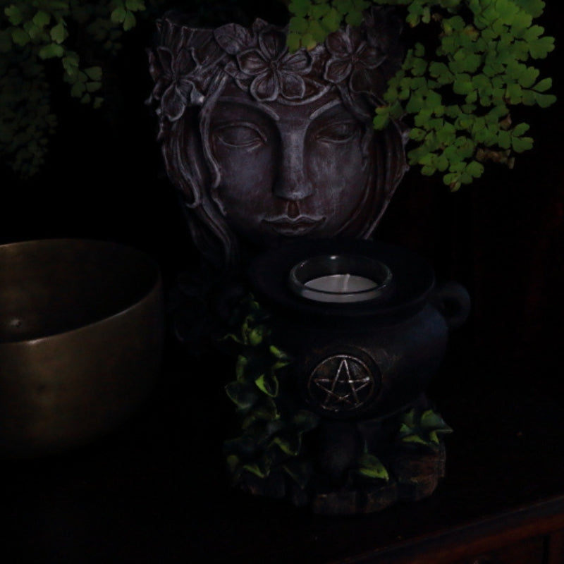 cauldron tealight candle holder in front of a lady planter next to a singing bowl