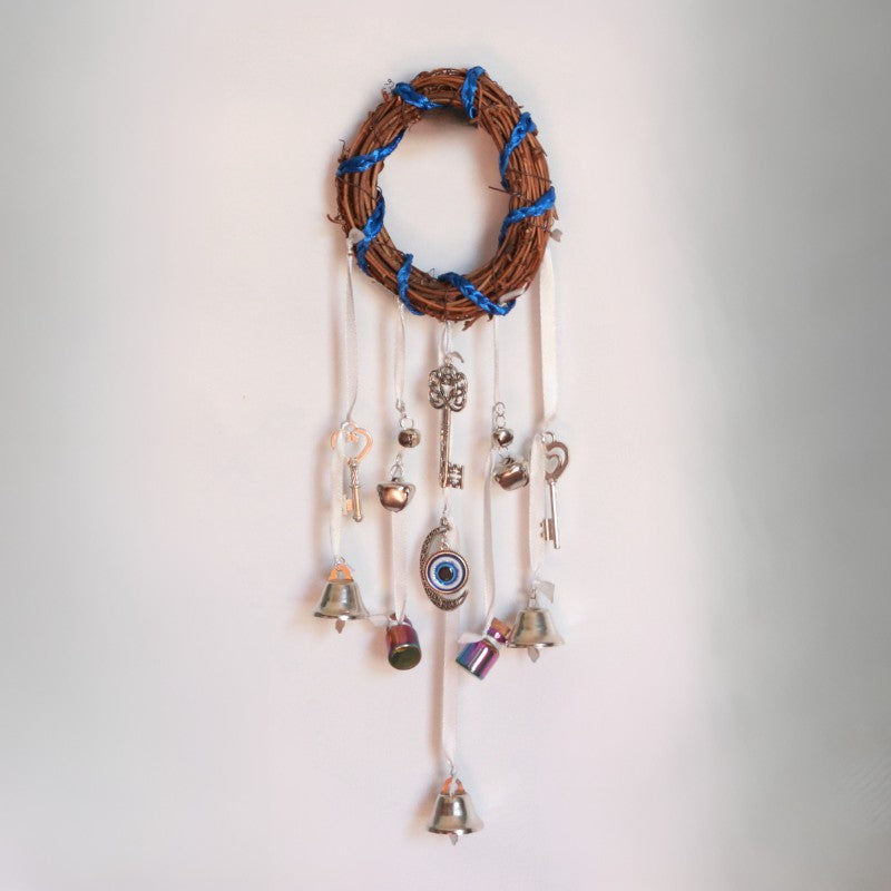 Decorative wall hanging with bells and charms on a plain background