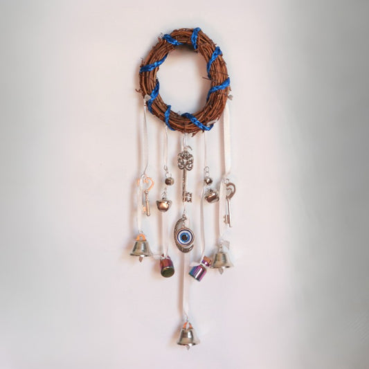 Decorative wall hanging with bells and charms on a plain background