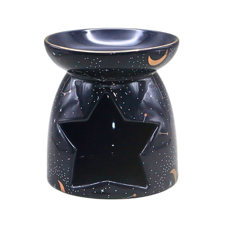 A ceramic oil burner with a star-shaped cutout on the front, featuring a glossy dark navy blue glaze decorated with white stars, small gold crescent moons, and tiny gold accents, set against a plain white background.