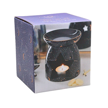 A star-shaped wax warmer candle with a glowing flame, displayed inside its blue and white box packaging.