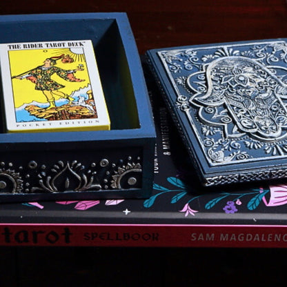 Blue Hamsa Tarot Card Storage Box with a pack of pocket sized rider waite tarot cards on a tarot book