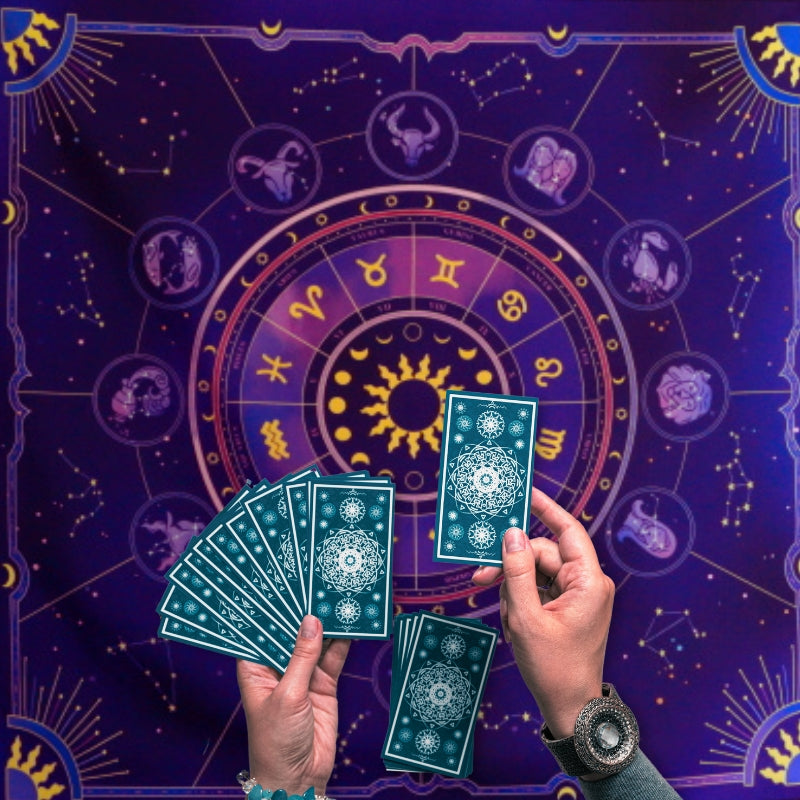woman laying tarot cards onto a purple tarot cloth with astrological signs printed on it
