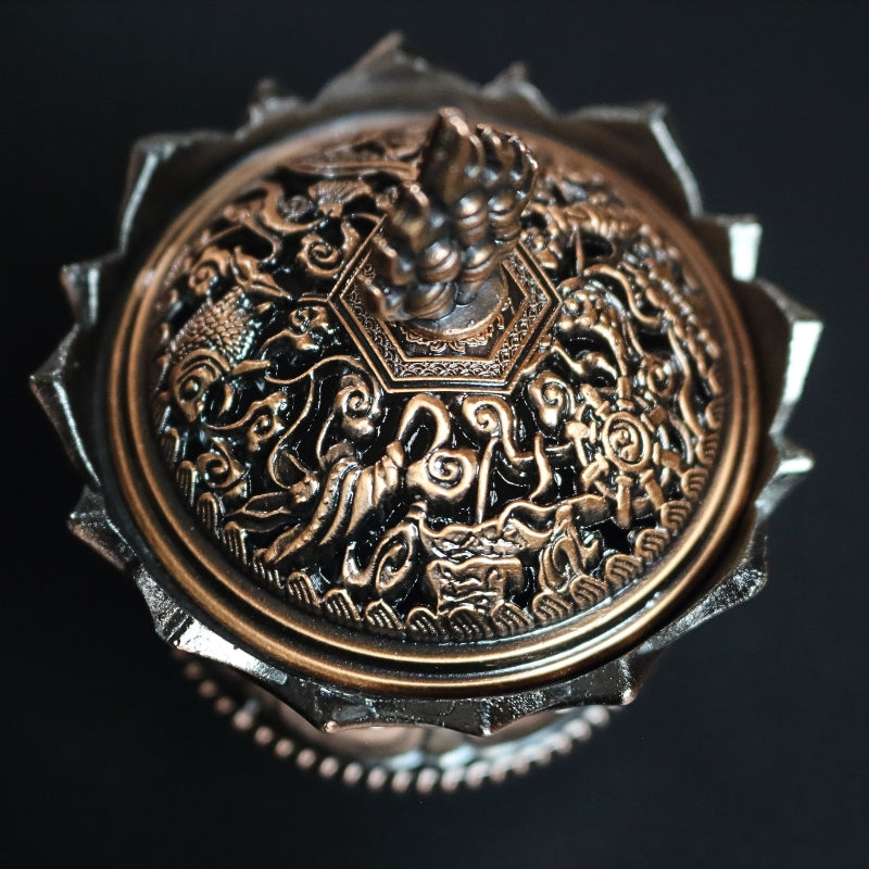 top view of an ornate red brass coloured 2 piece censer/ loose incense burner on a black background