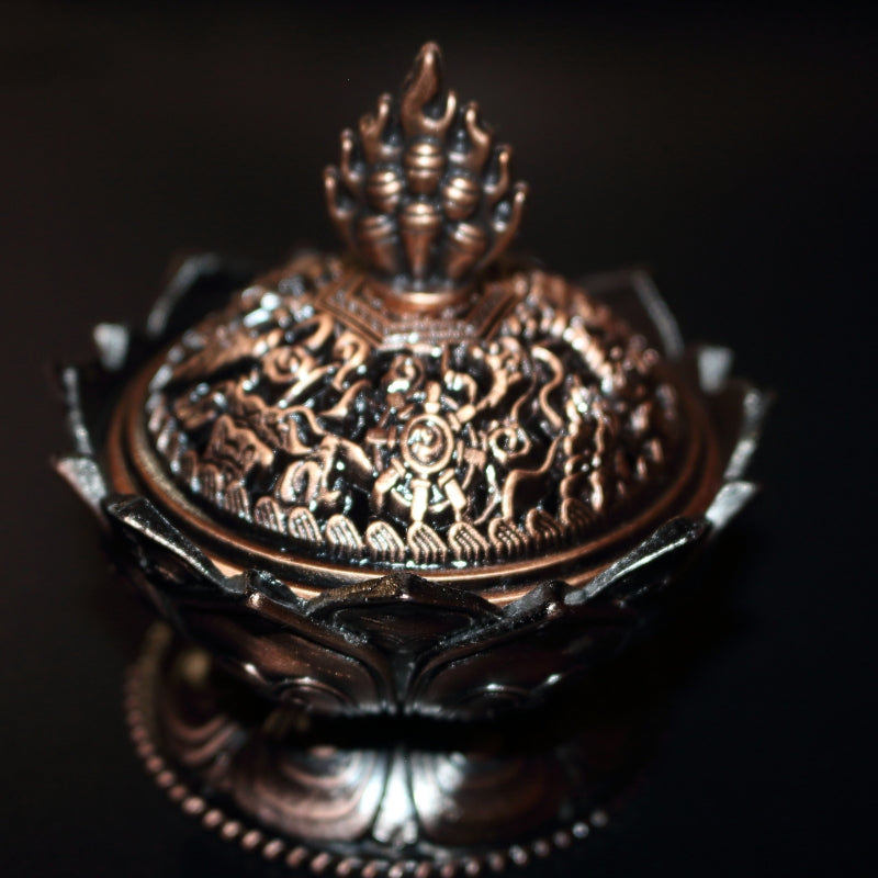 front view of an ornate red brass coloured 2 piece censer/ loose incense burner on a black background