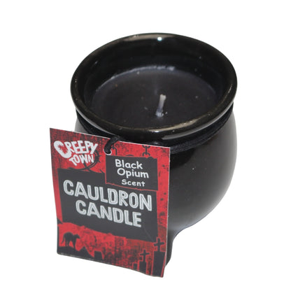 Black wax candle in a black ceramic cauldron