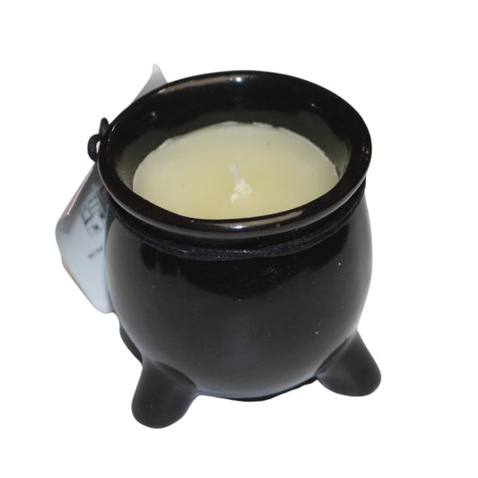 White wax candle in a black ceramic cauldron