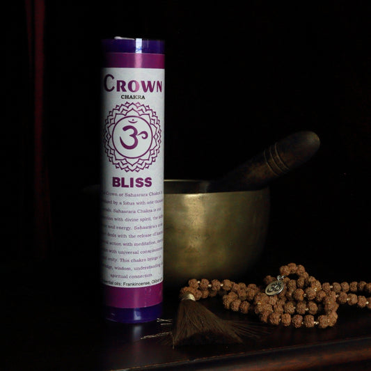 Purple Crown  chakra pillar candle in front of a singing bowl with mala beads